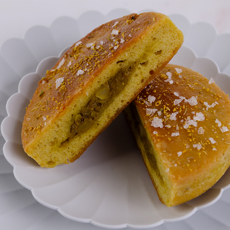 Vadouvan Spiced Flat Bread filled with Vadouvan Spiced Sweet Onion and Almond, sliced in half