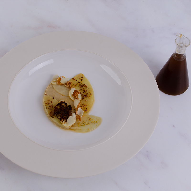 Silken Avola Almond with Salt-baked Parsnip plated alongside celeriac and artichoke broth